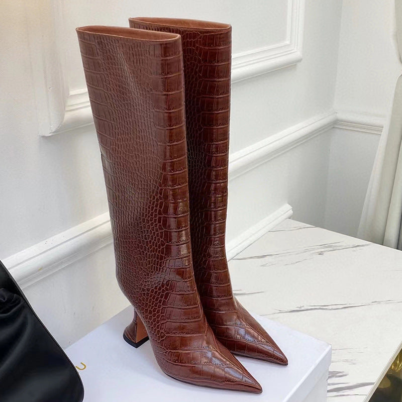 Brown crocodile-embossed leather knee-high boots with pointed toes and sculpted stiletto heels.