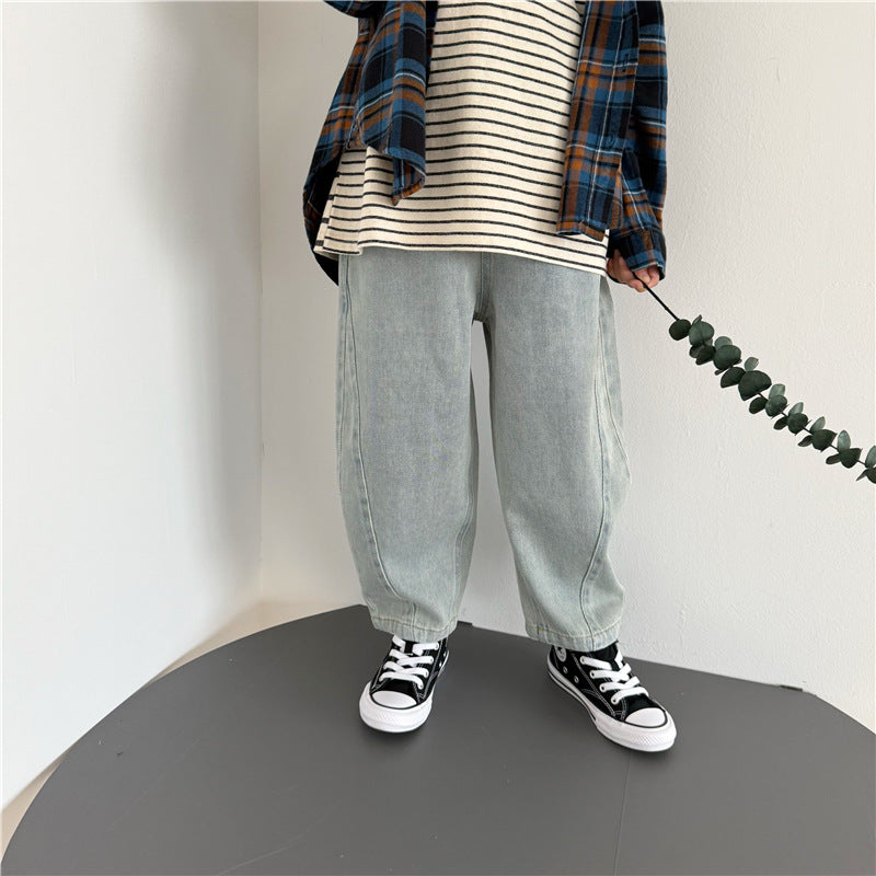 Light-wash denim jeans with a wide-leg, curved-seam style, paired with black and white sneakers.