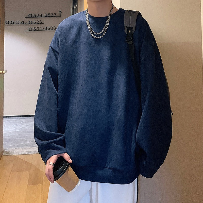 Dark blue oversized crewneck sweatshirt in plain fabric, worn casual with a layered silver chain necklace.