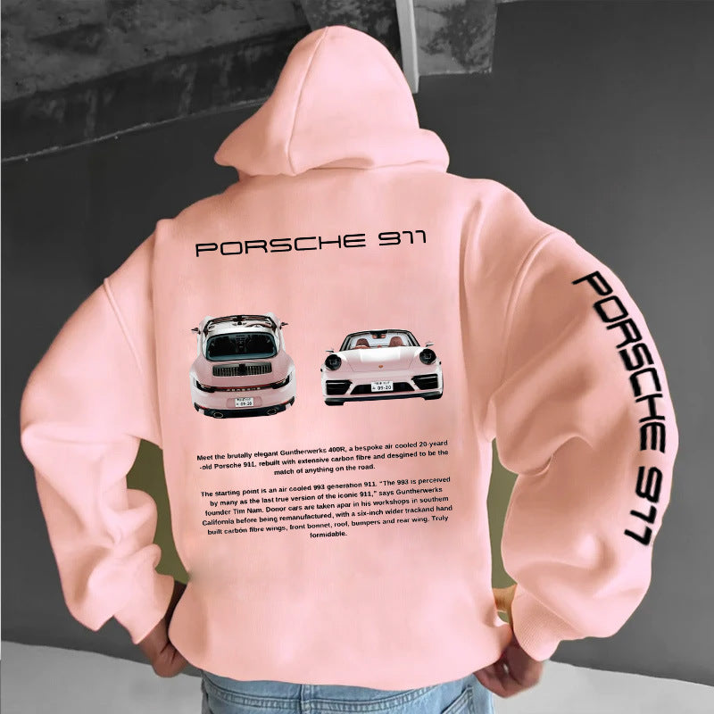 A person wearing a loose, light pink hoodie with Porsche 911 graphics and text on the back and left sleeve.