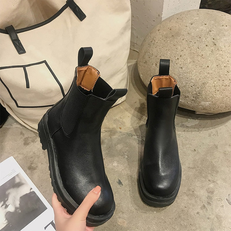 Black faux leather Chelsea boots with pull tabs and thick lug soles.