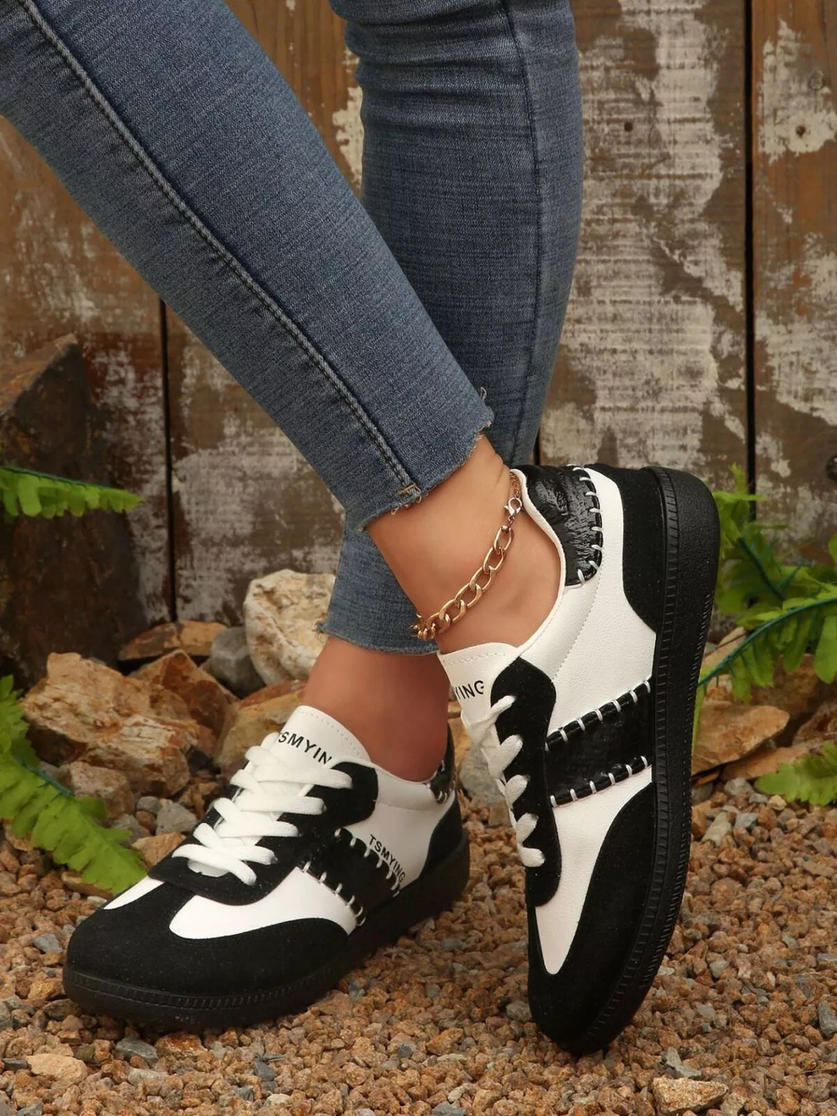 Contrast lace-up sneakers from Trendsi featuring black and white design, with white rubber soles and stylish athletic footwear.