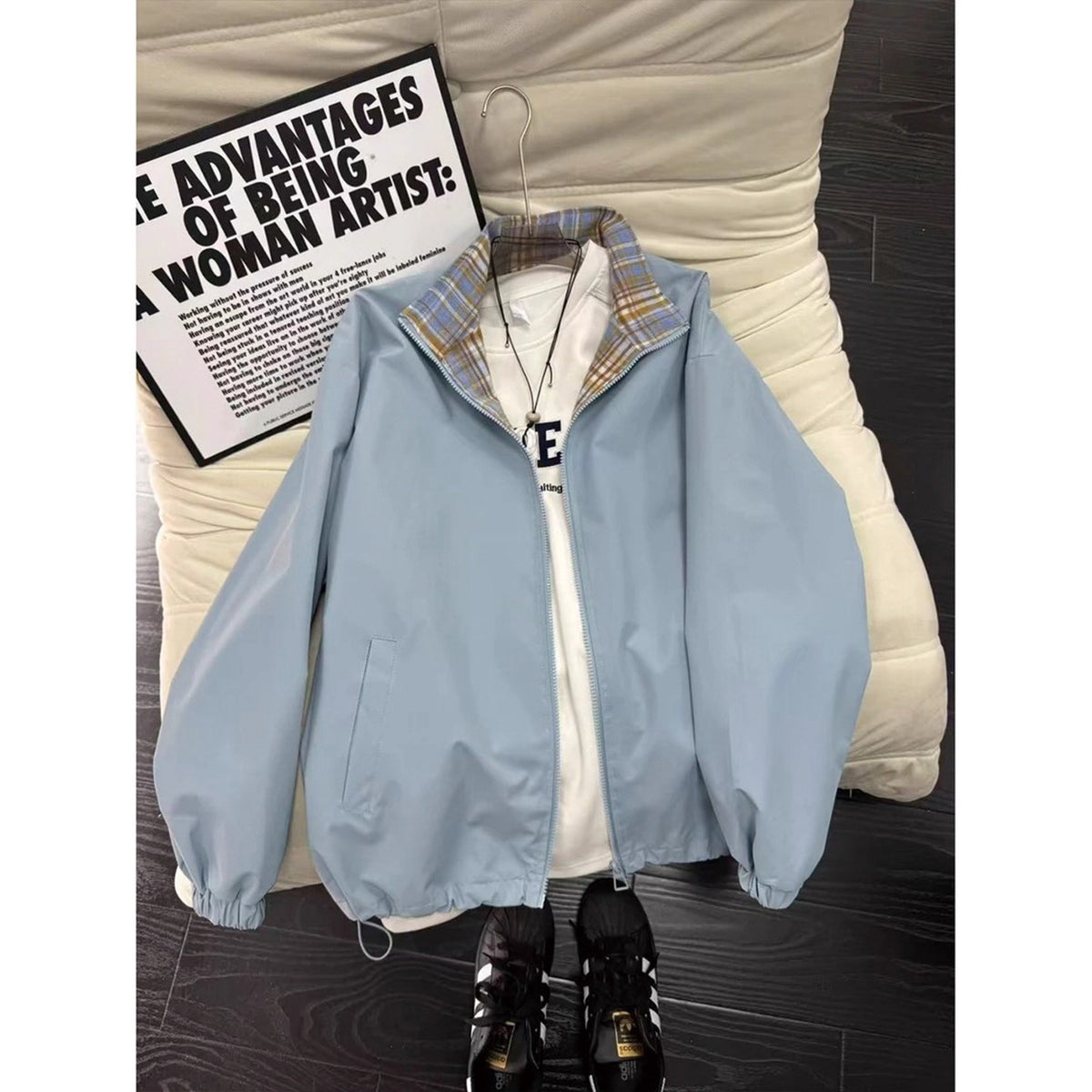 Light blue zip-up jacket with plaid collar, layered over a white t-shirt and paired with black sneakers.
