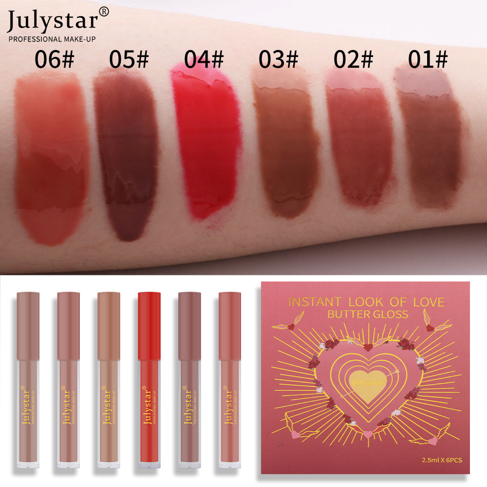 Six Julystar lip glosses with swatches in peach, brown, red, and nude shades next to a red love-themed box.
