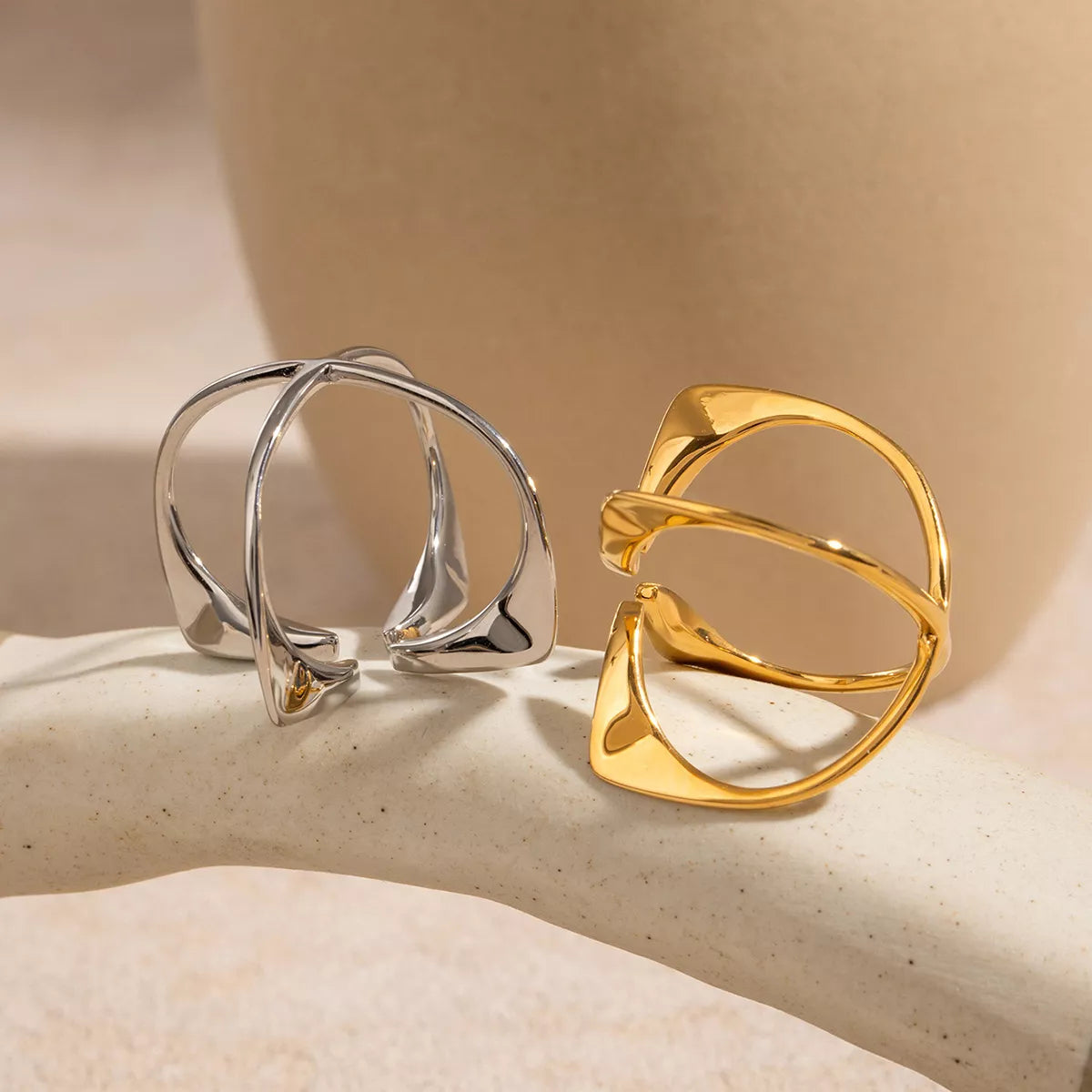 Stainless steel crisscross open ring with sleek design, featuring intersecting bands, from Plush Fashion Hub.