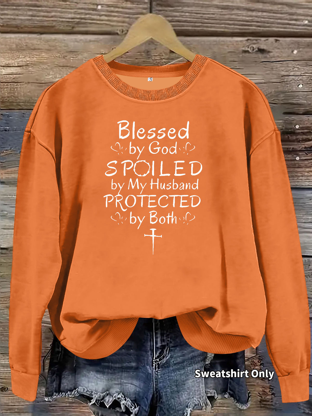 Orange crewneck sweatshirt with white text reading Blessed by God, SPOILED by My Husband, PROTECTED by Both.