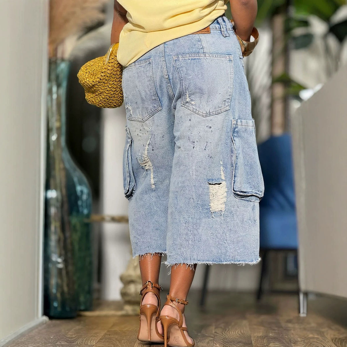 Ripped raw hem multi-pocket cargo seven-eighth denim jeans by Plush Fashion Hub, featuring distressed details and functional pockets.