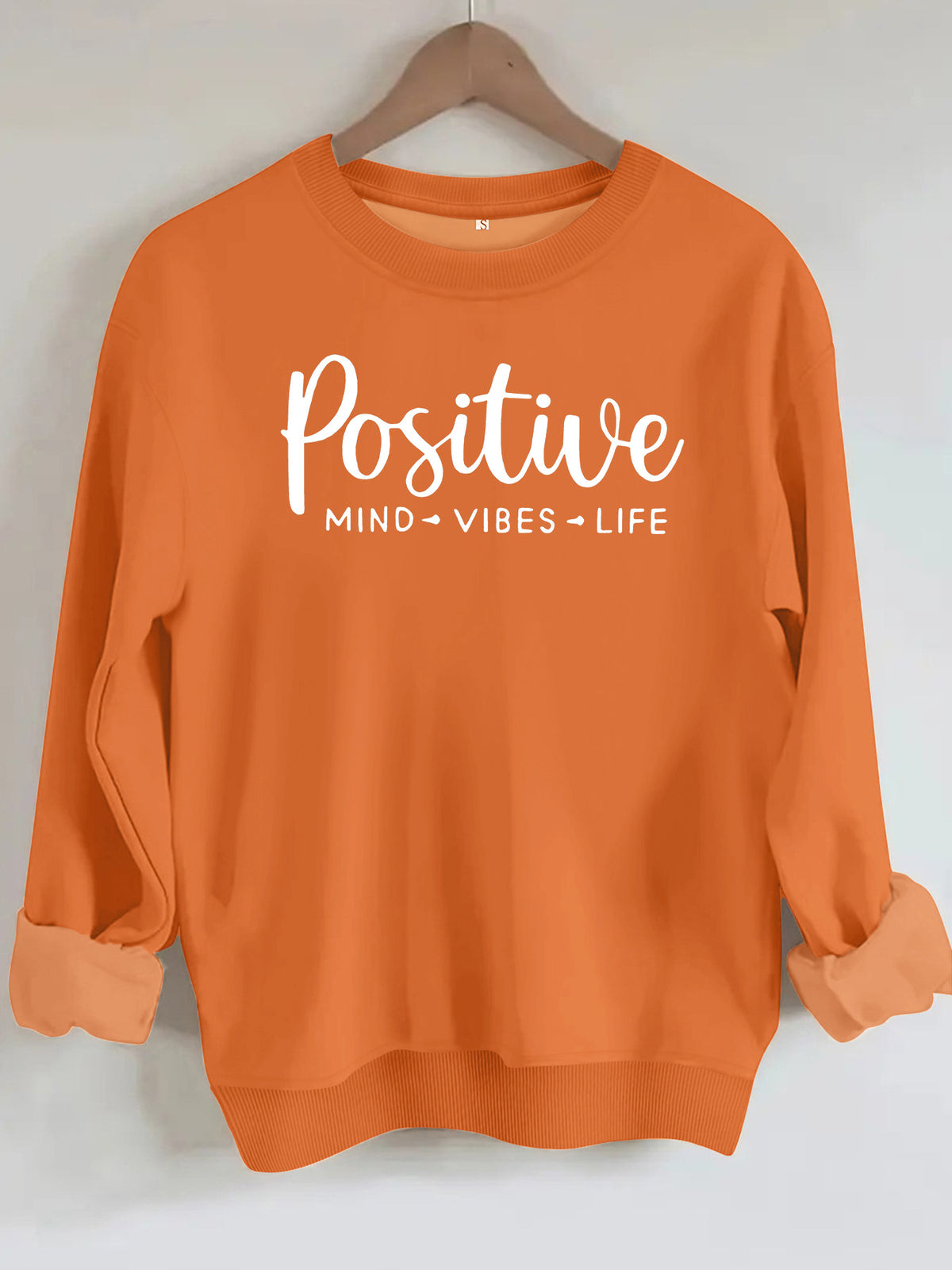 Orange cotton sweatshirt with white text "Positive MIND VIBES LIFE" on the chest, crew neck, and cuffed sleeves.