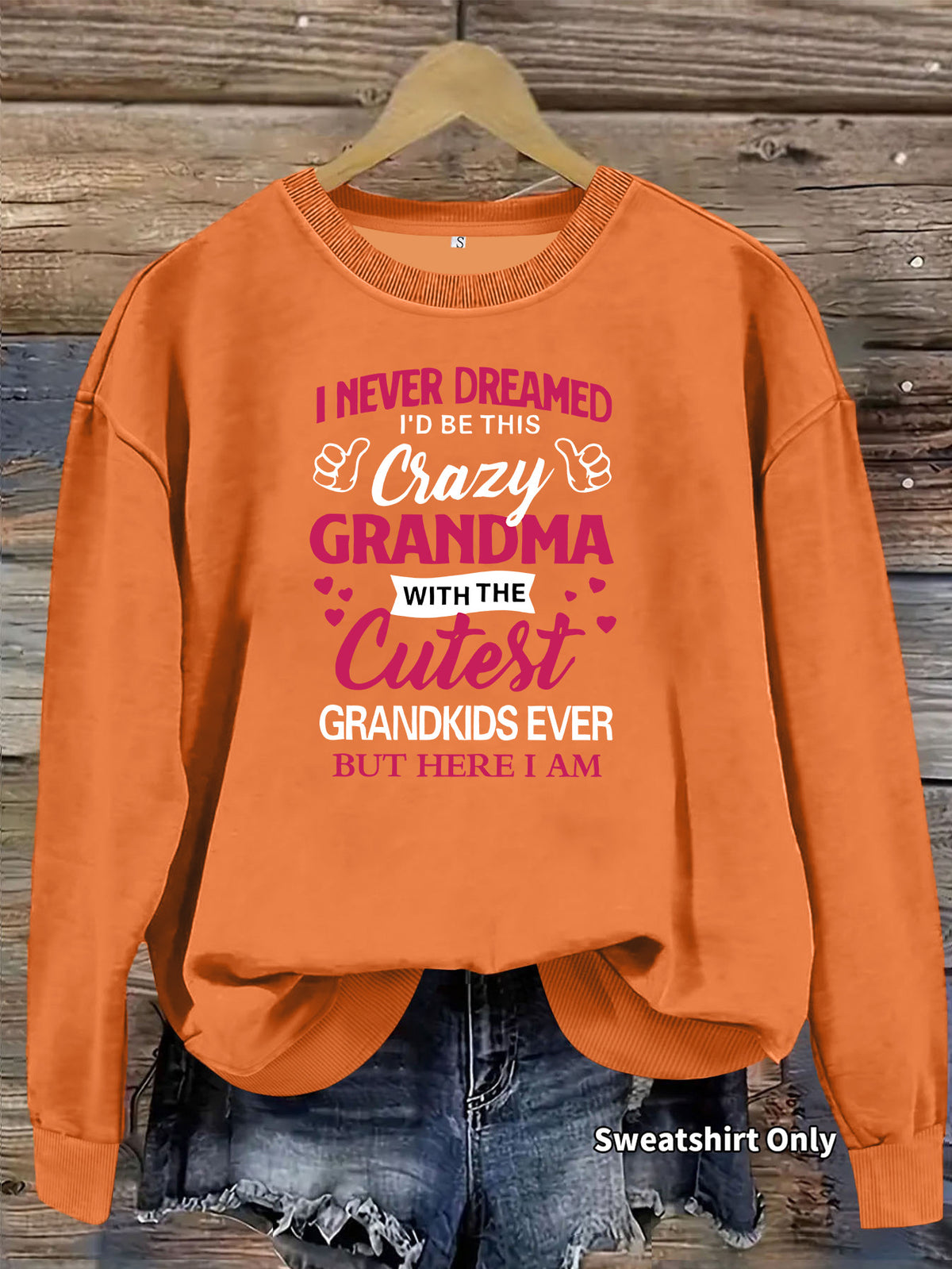 Orange crewneck sweatshirt with "Crazy Grandma" graphic text, ribbed cuffs, and hem.