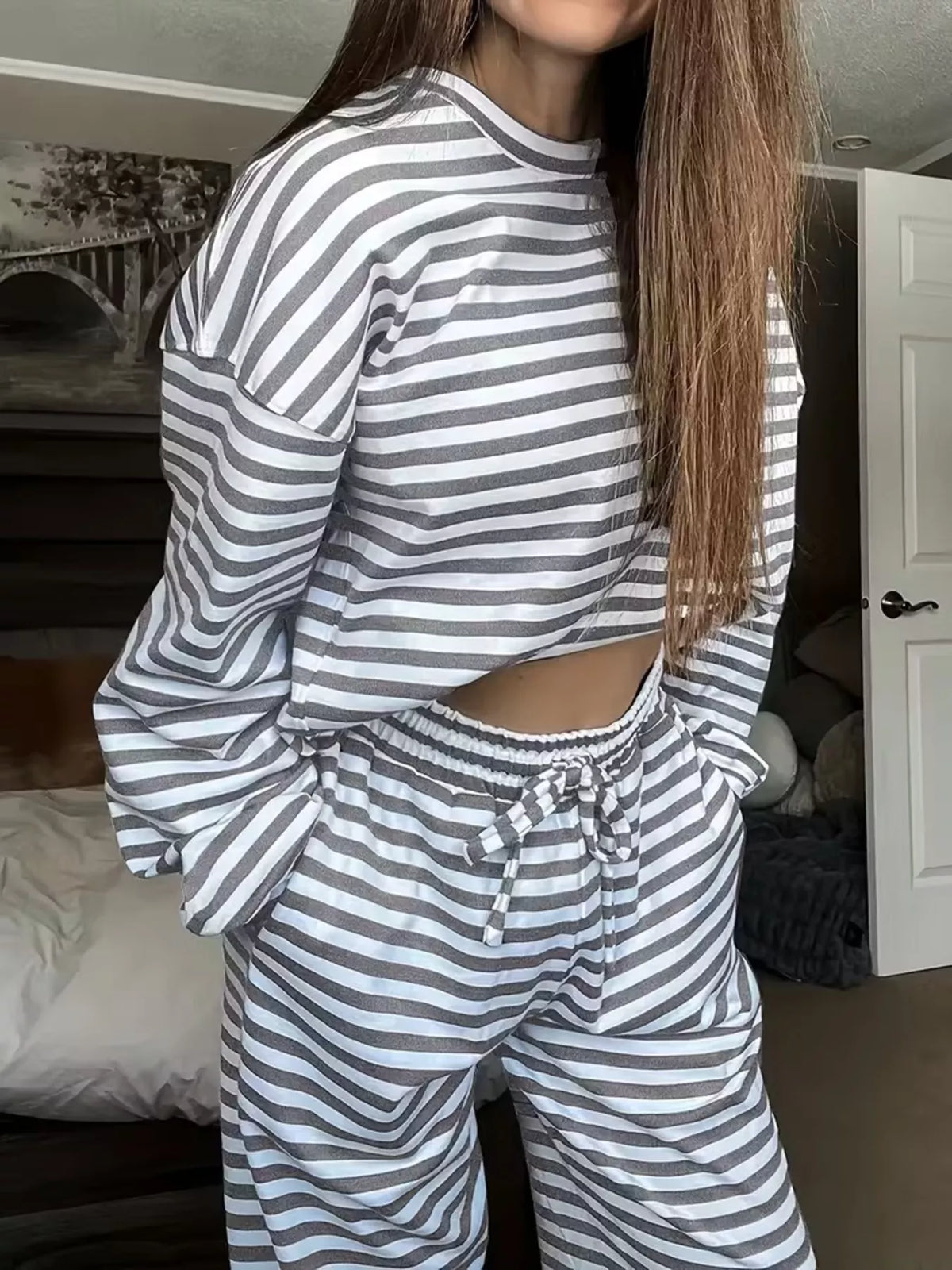 Striped dropped shoulder top and pants set by Trendsi featuring a relaxed fit and stylish casual design.