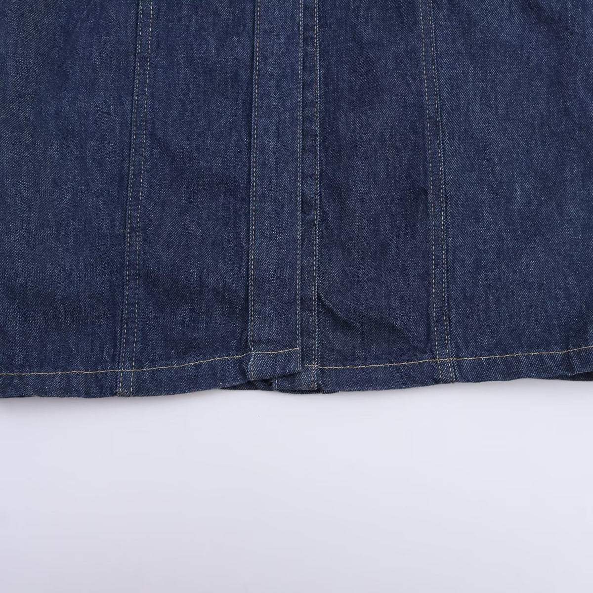 Dark blue denim jacket with contrast stitching, vertical seams, and hem detail.