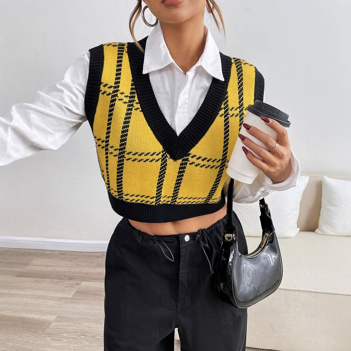 Yellow and black knit sweater vest in a plaid pattern with a V-neck, layered over a white button-down shirt.