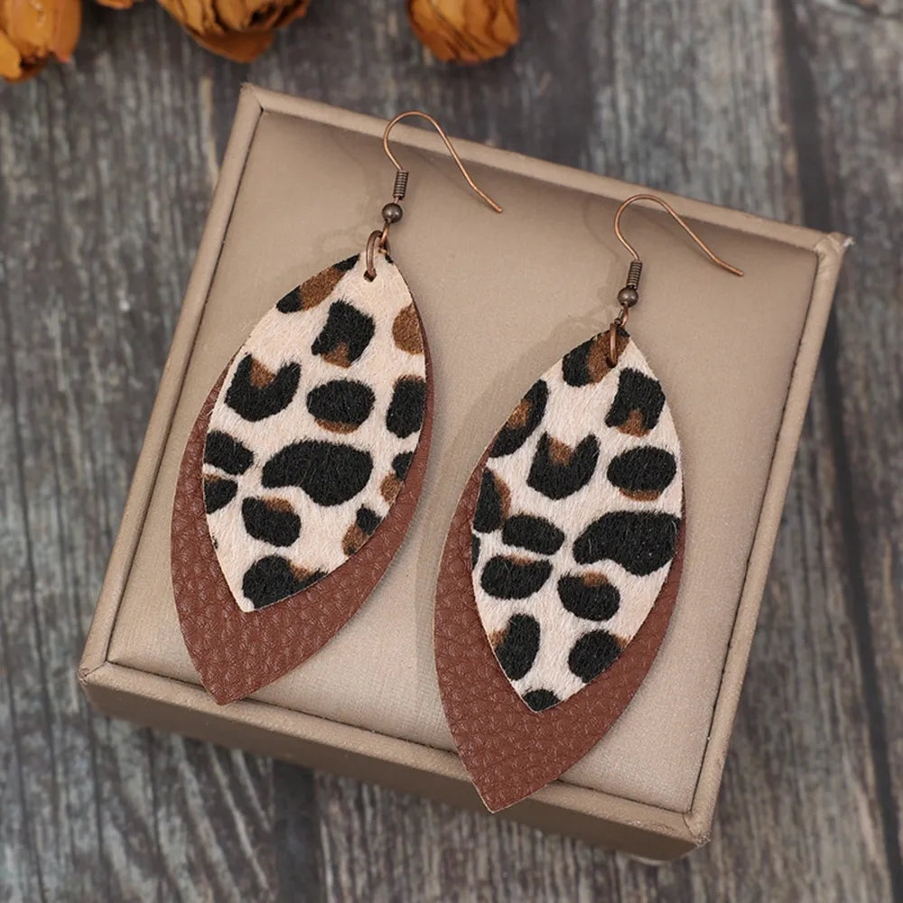 Leaf shape leather dangle earrings in natural brown with gold accents, stylish jewelry accessory from Plush Fashion Hub.