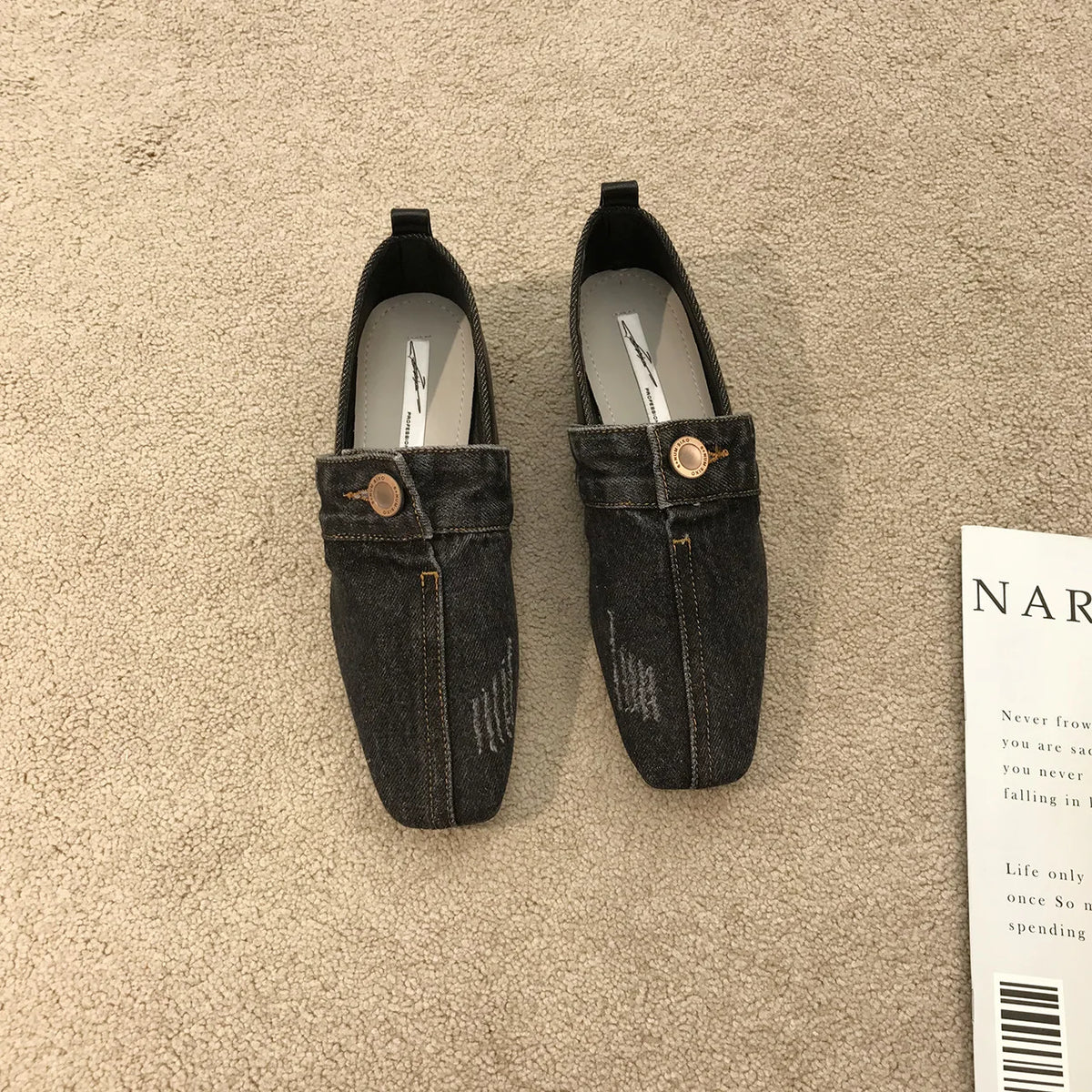 Pair of dark gray denim loafers featuring square toes, distressed details, center seams, and gold-toned button accents.