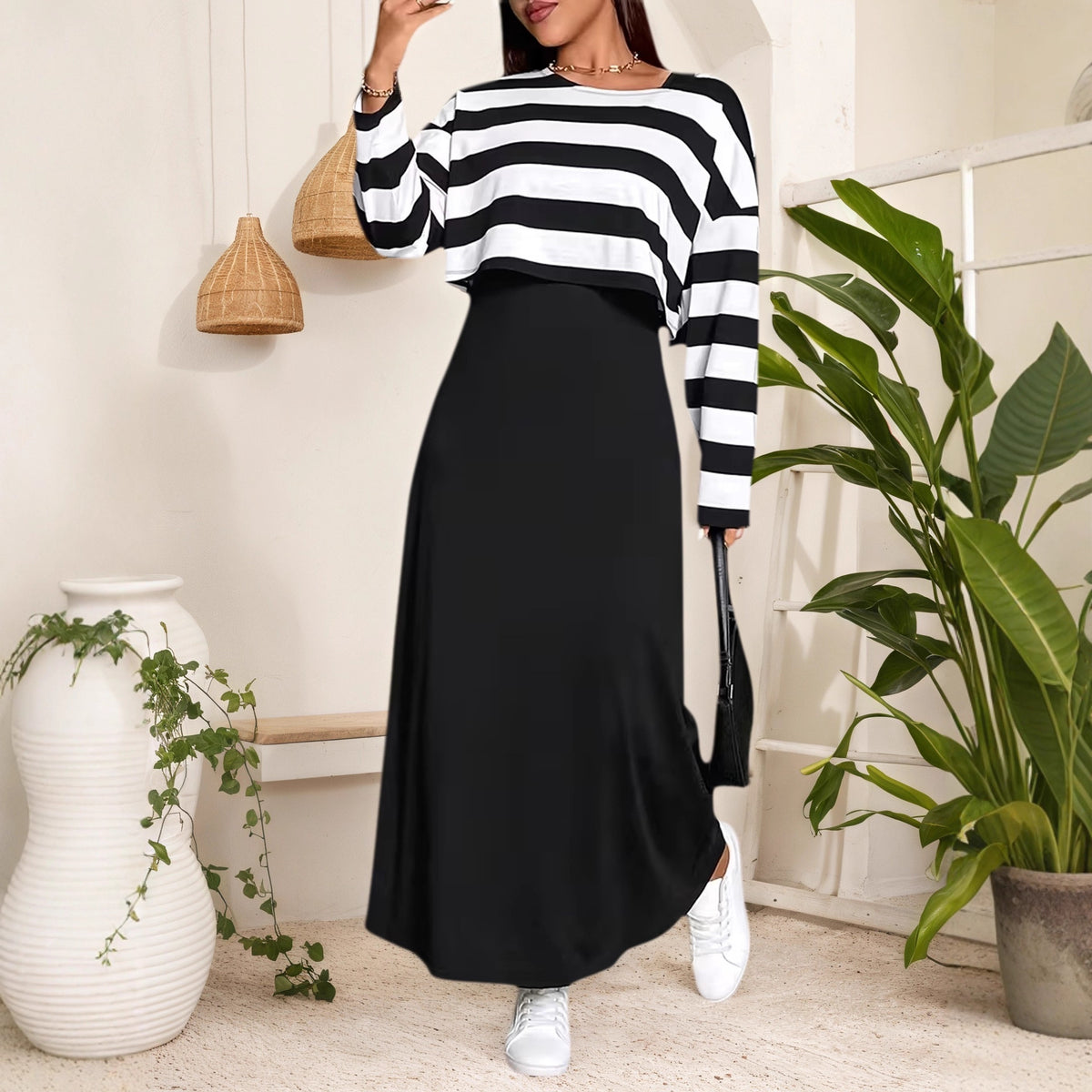 Black and white striped long sleeve crop top layered over a solid black maxi dress.