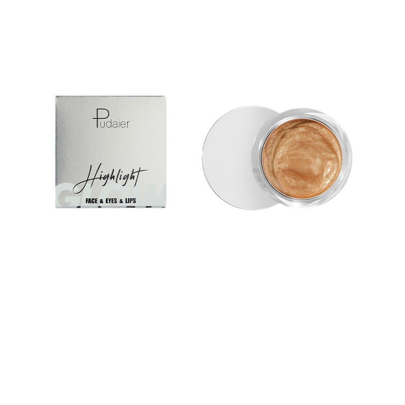 Pudaier face, eyes, and lips highlight jar with metallic gold cream, next to a silver box.