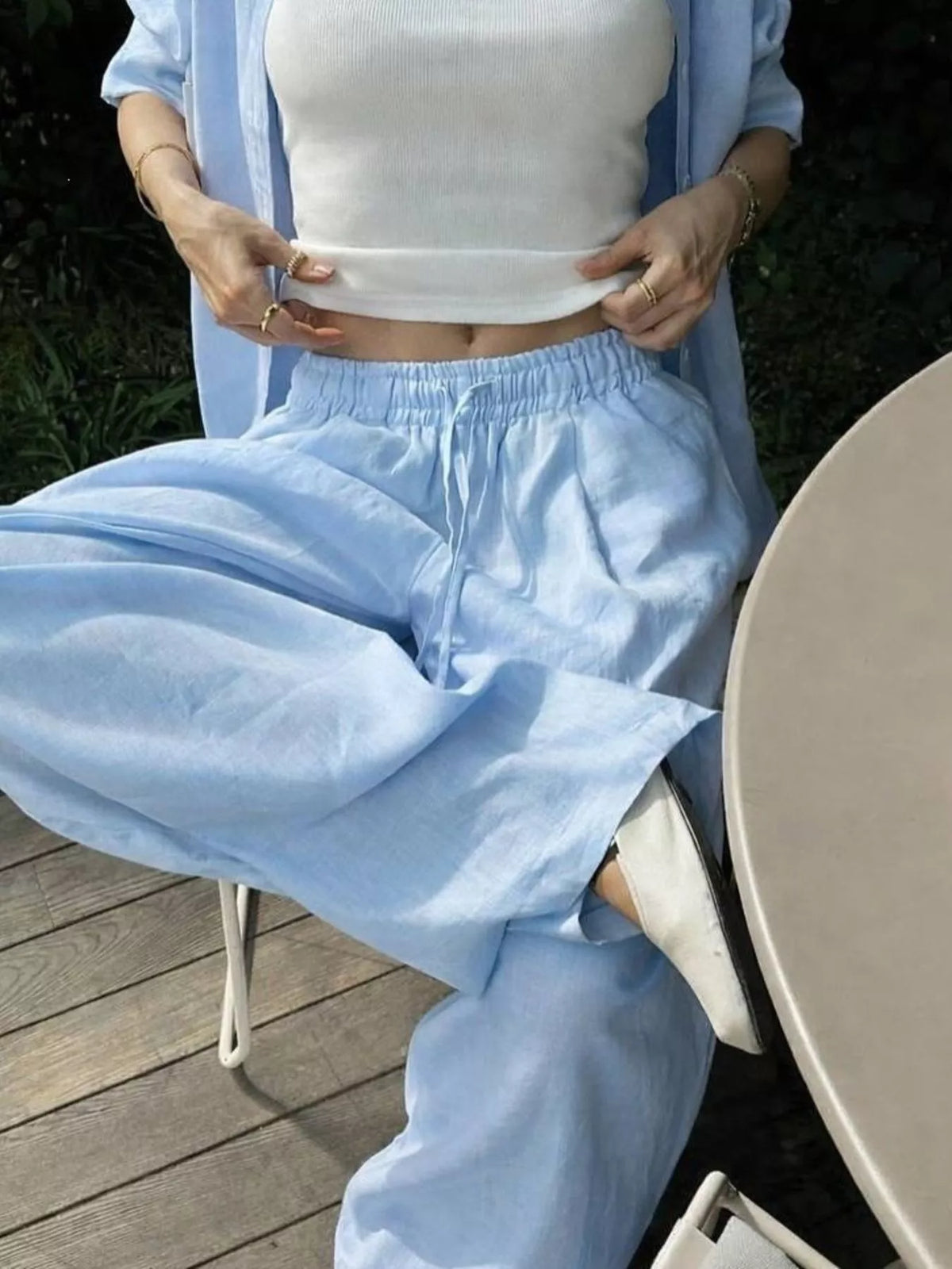Plush Fashion Hub loungewear set featuring a button-up shirt and drawstring pants, displayed on a model in a cozy indoor setting.