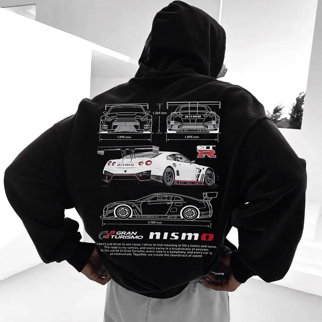 A person wearing a black long-sleeve hoodie featuring white racing car graphics on the back.