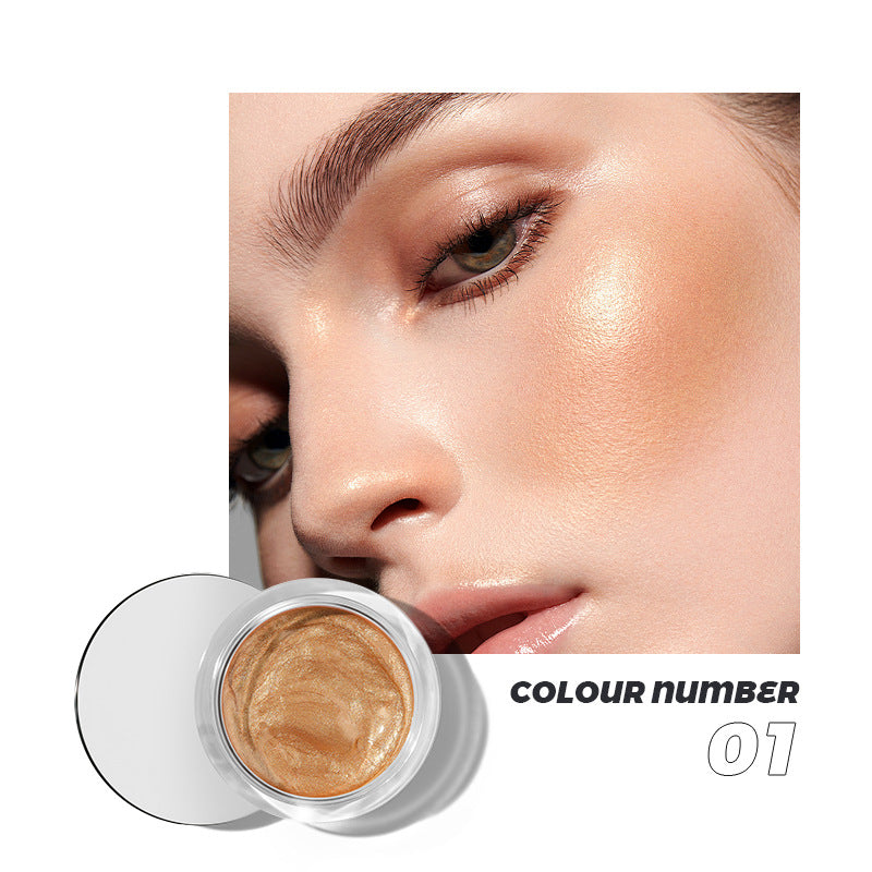 Shimmery gold makeup in a clear glass jar, applied on a woman’s cheekbones.