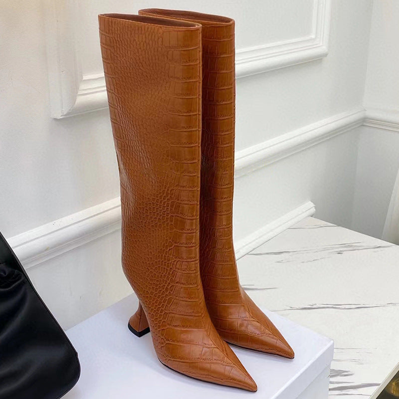 Tan brown knee-high boots in faux crocodile leather, featuring pointed toes and curved flared heels.
