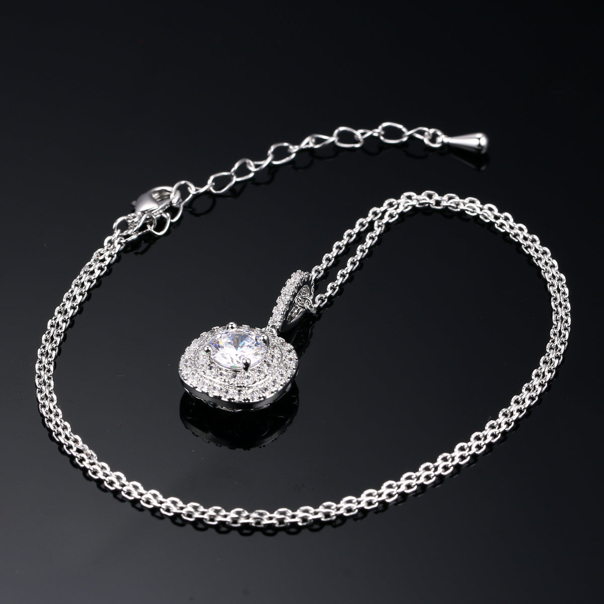Silver metal pendant necklace with a round rhinestone halo centerpiece on a double link chain.