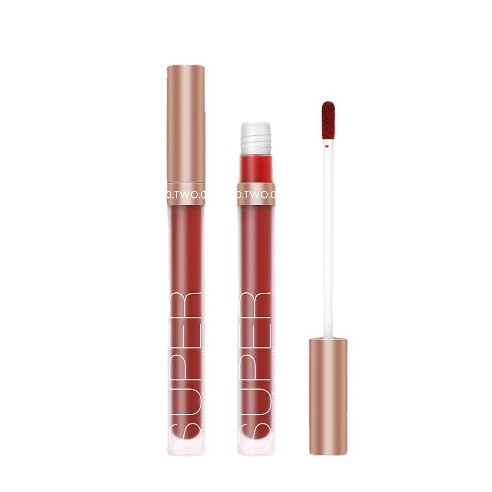 Red liquid lipstick with metallic rose-gold cap and white text "SUPER", shown with applicator brush.