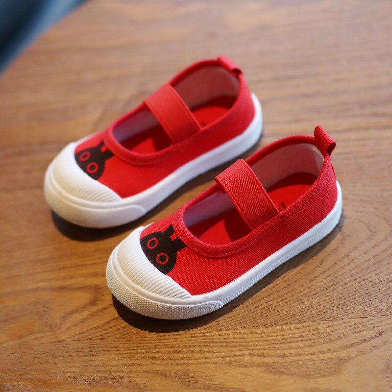 Red canvas Mary Jane shoes with white rubber soles, black bunny graphic toes, and elastic straps.