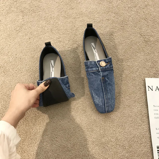 Blue denim flat shoes with a button detail and flexible sole.