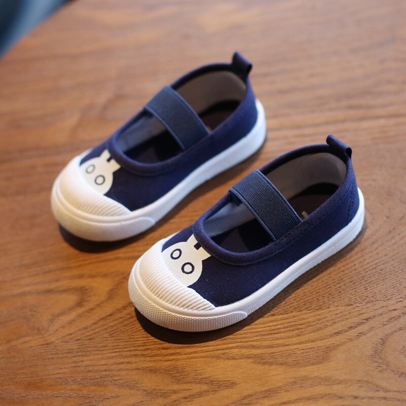 Dark blue canvas children's shoes with elastic straps, white toe caps, and white bunny face graphics.