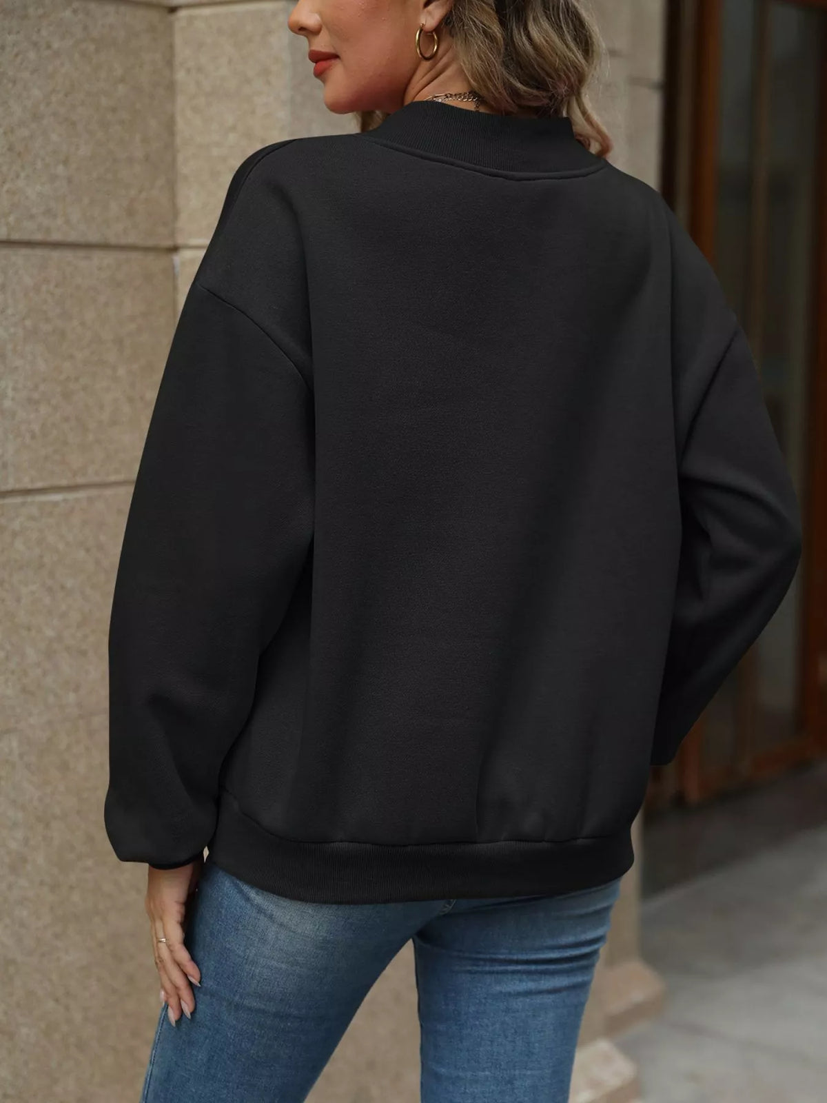 V-neck solid color casual sweatshirt by Trendsi, showing a close-up of the soft fabric and relaxed fit in a neutral tone.