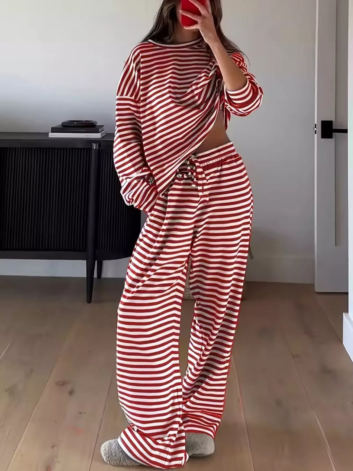 Striped dropped shoulder top and pants set by Trendsi featuring a stylish, relaxed fit with bold horizontal stripes.