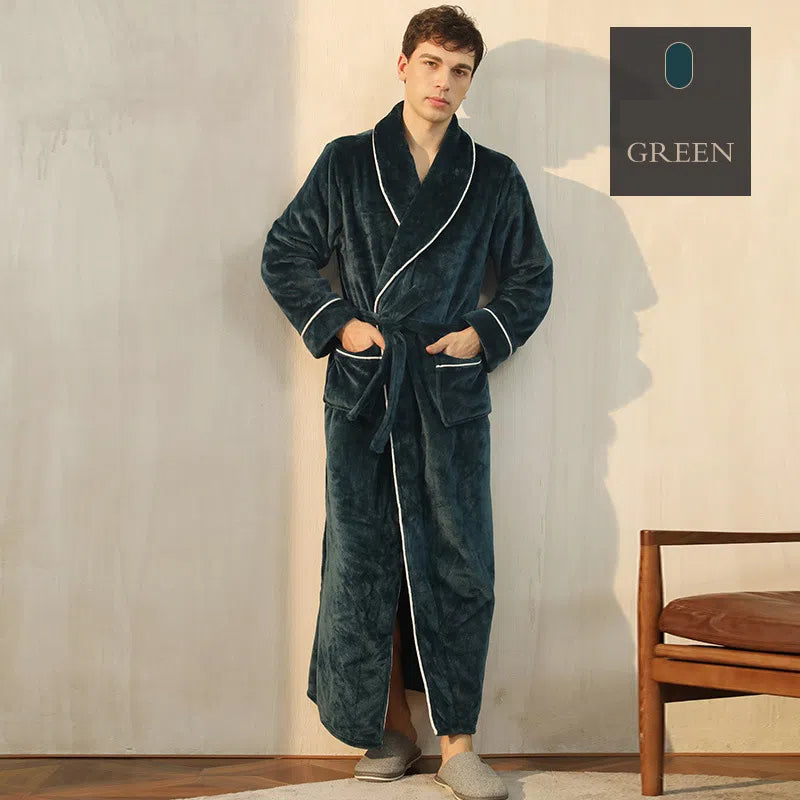 A man wears a solid green plush fleece bathrobe with shawl collar, white piping, tie belt, and two pockets.