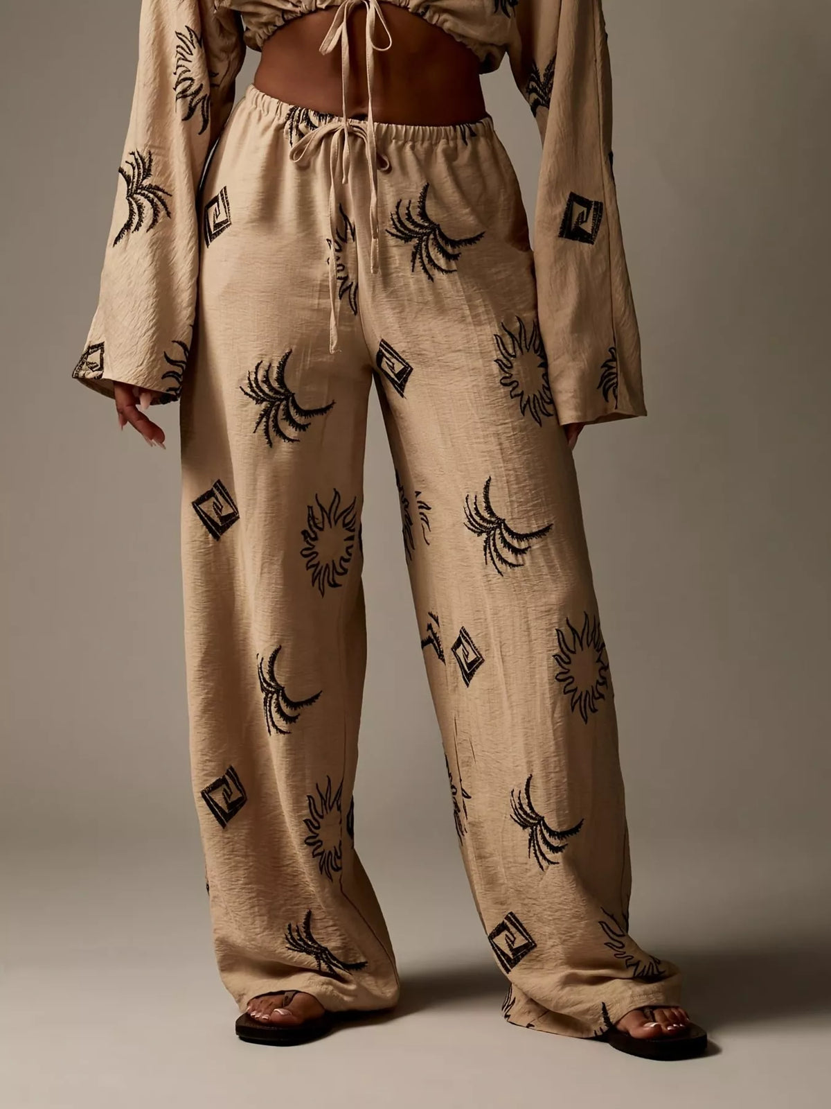 Printed crop top and wide-leg pants set for women by Trendsi, featuring a stylish, coordinated outfit with vibrant patterns