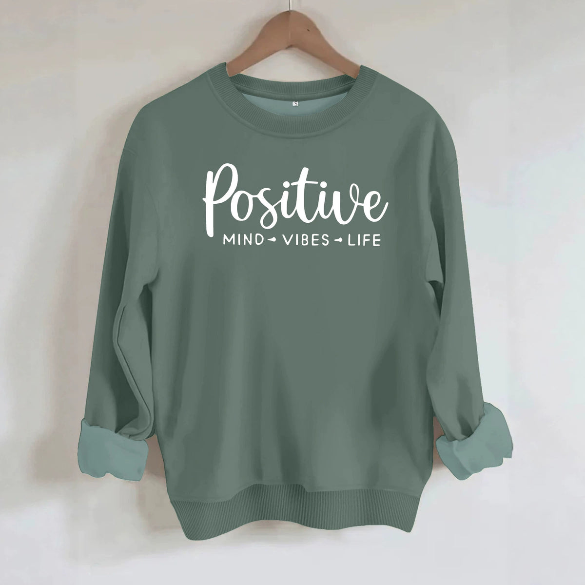 Sage green cotton crewneck sweatshirt with "Positive MIND VIBES LIFE" text.