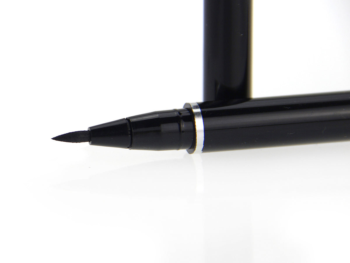 Glossy black liquid eyeliner pen with a fine felt tip and a silver accent ring.