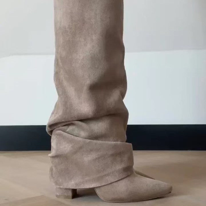 Beige suede slouchy knee-high boots with pointed toe, folded cuff, and low block heel.