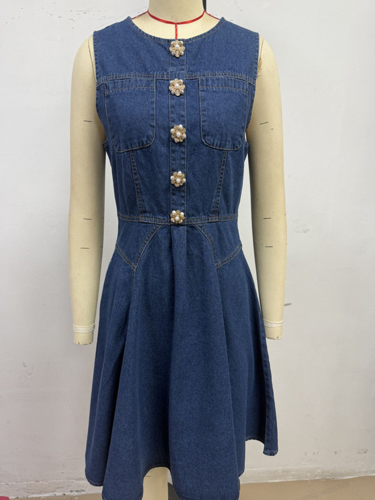 Women's sleeveless denim mini dress by Plush Fashion Hub featuring stretchy cotton blend fabric and button-front design.