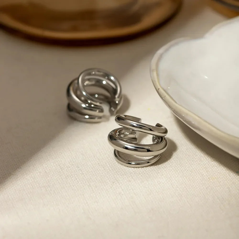 Stainless steel layered cuff earrings with multiple overlapping bands, stylish jewelry accessory from Plush Fashion Hub.