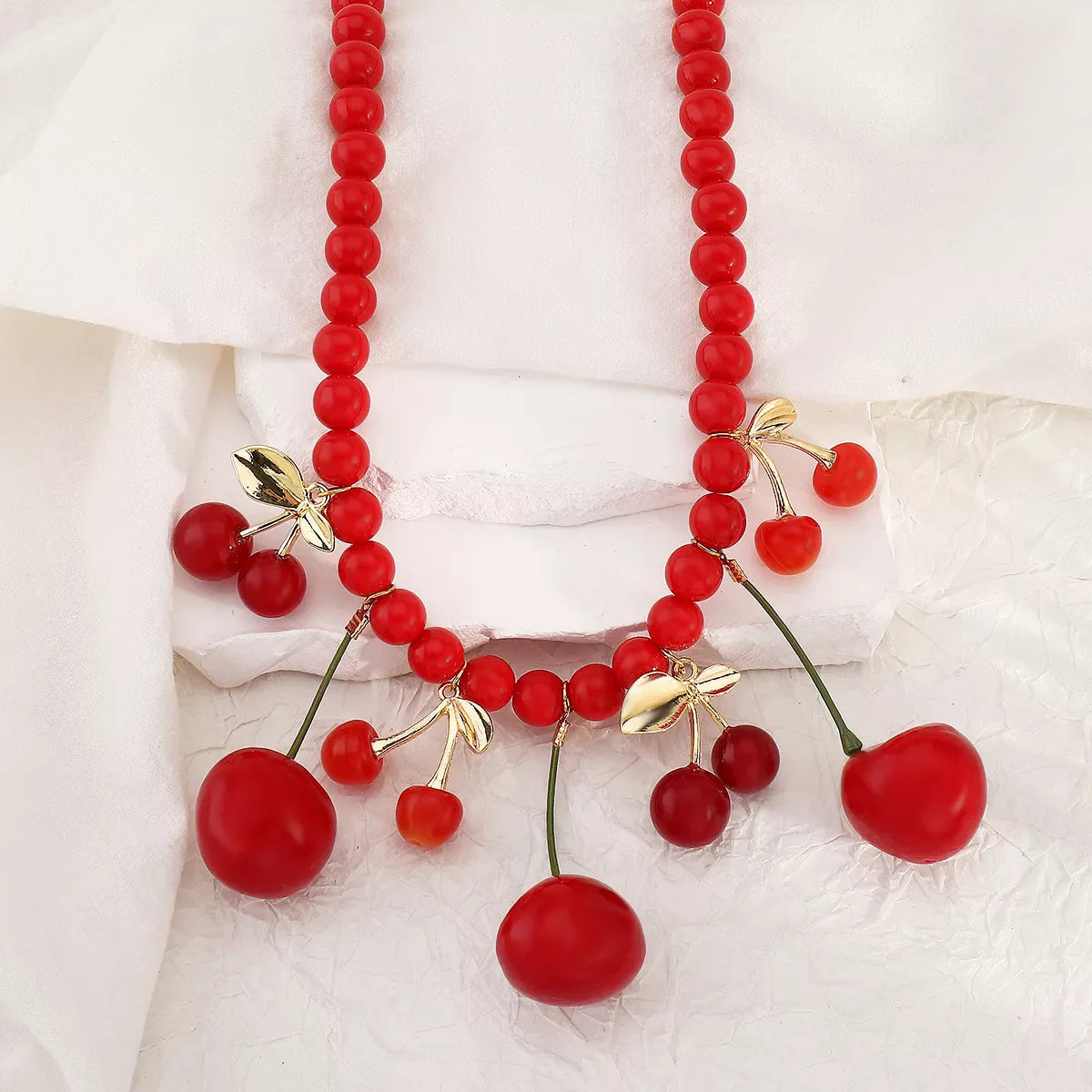 Beaded Cherry Charm Necklace by Plush Fashion Hub featuring colorful cherry-shaped beads on a stylish necklace design.