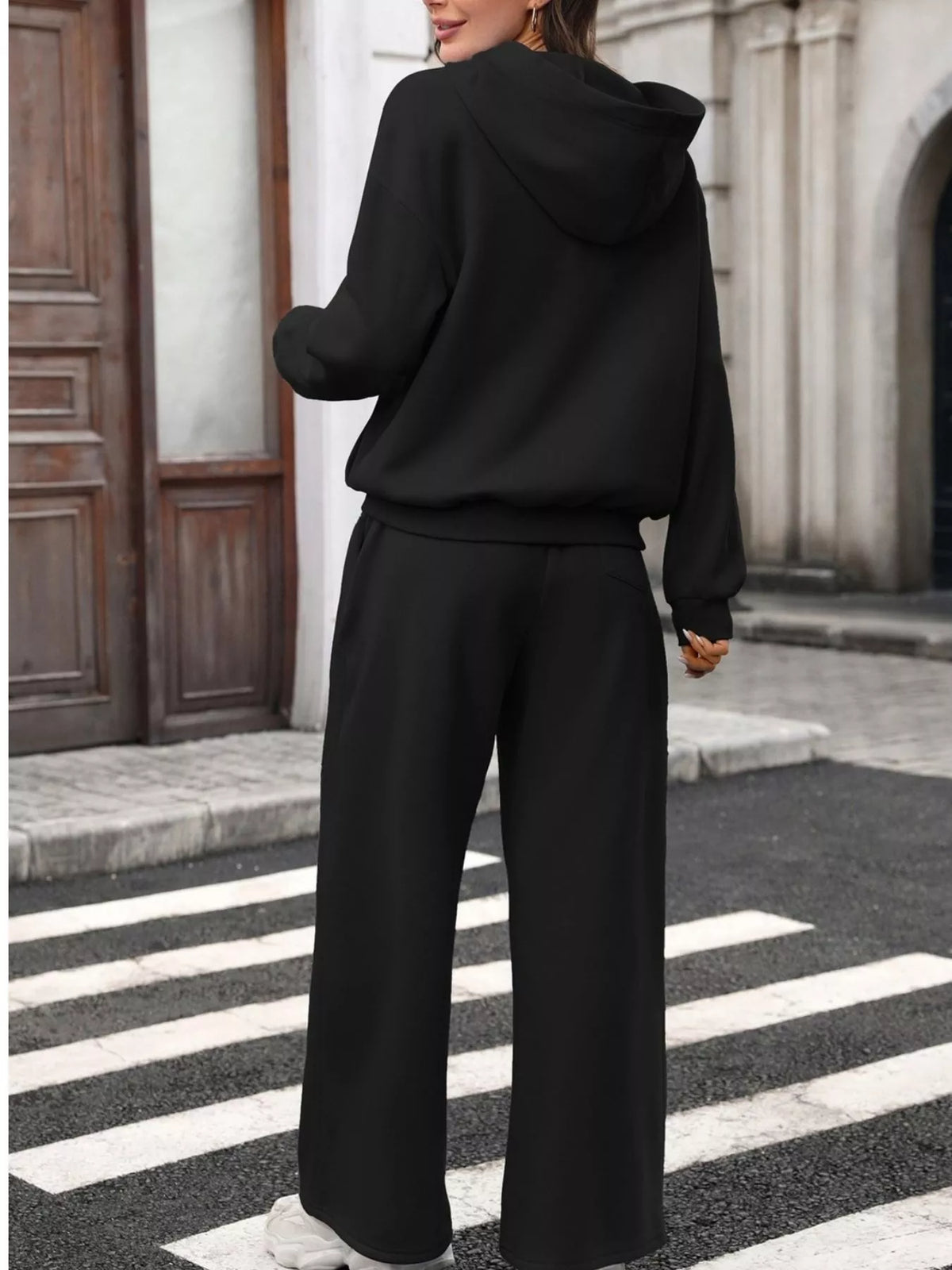 Women's kangaroo pocket hoodie and wide-leg pant set by Trendsi, featuring a cozy hoodie and relaxed fit pants in soft fabric.