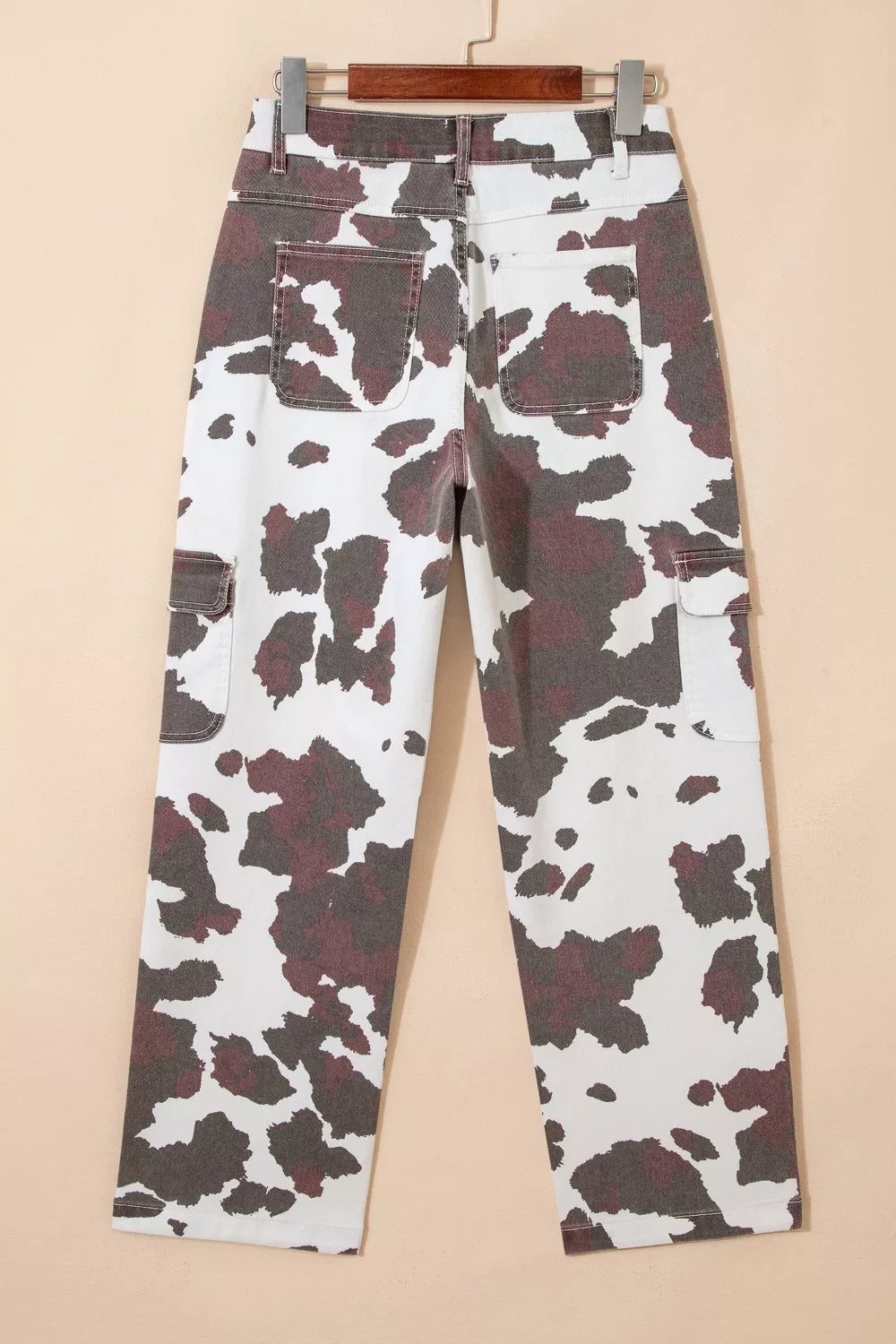 Plush Fashion Hub cow print jeans with multiple pockets, featuring black and white cow spots and a stylish casual design.