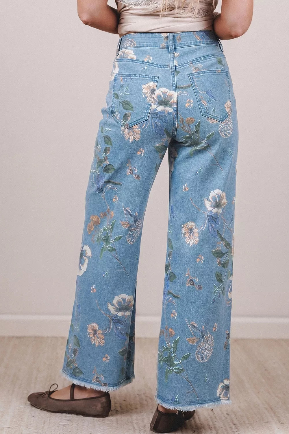 Floral print wide-leg jeans by Trendsi featuring a relaxed fit and vibrant floral pattern on denim fabric.