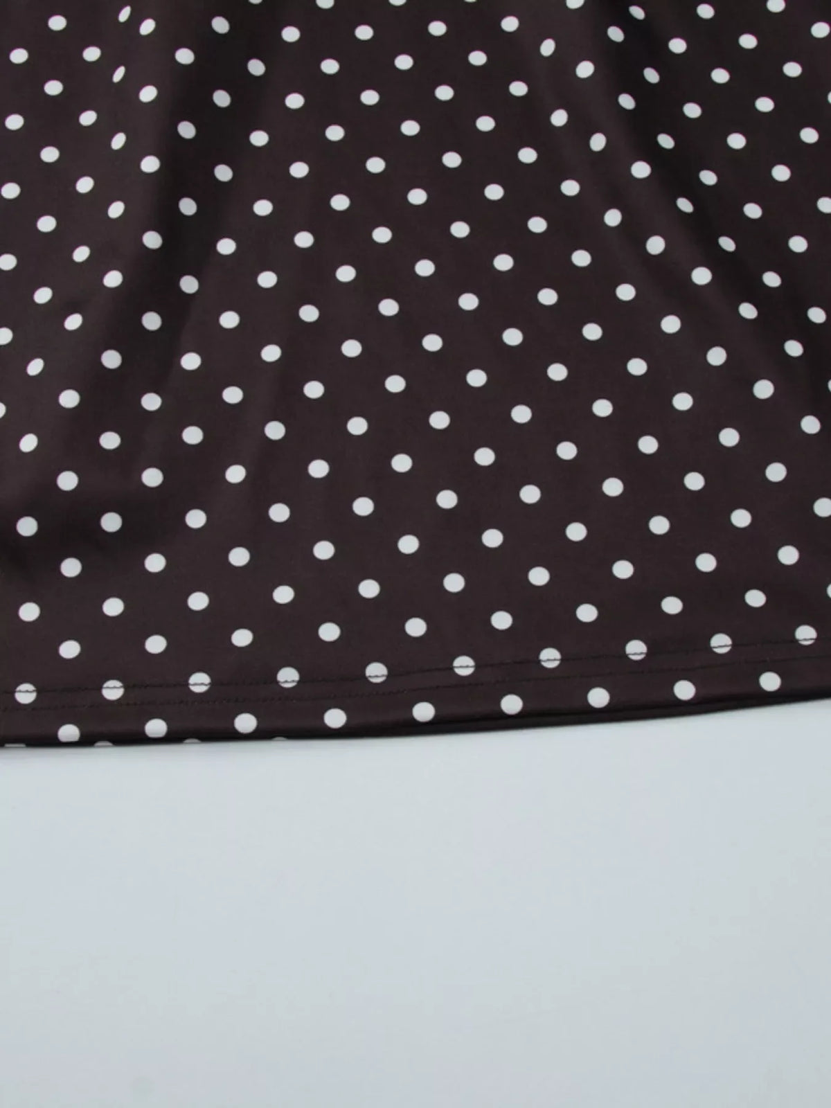 Polka dot mini dress with cut-out front by Plush Fashion Hub, featuring a stylish design and fitted silhouette.