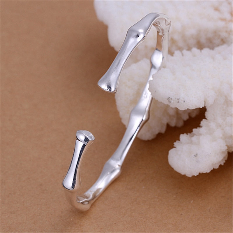 Silver metal cuff bracelet styled like bamboo segments with an open gap.