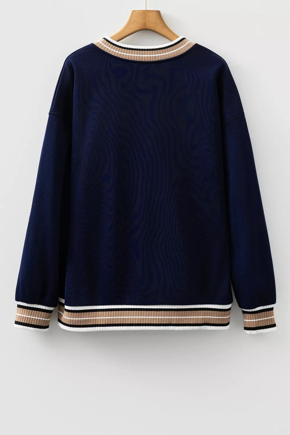Contrast striped trim V-neck sweatshirt from Trendsi, featuring a casual fit and bold stripe details on a soft fabric background.