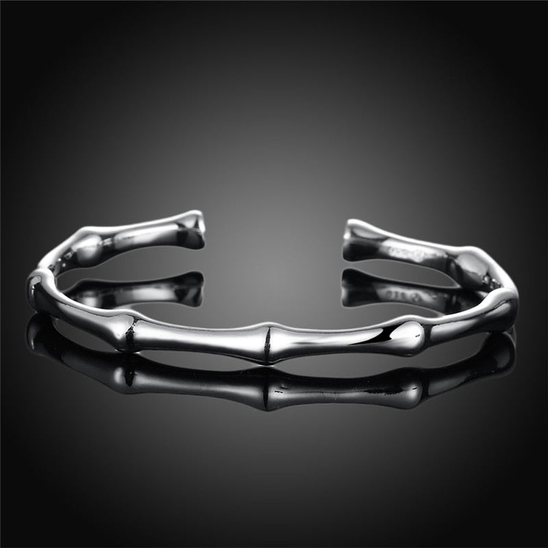 Silver metal cuff bracelet styled like bamboo joints, with a polished finish and open ends.