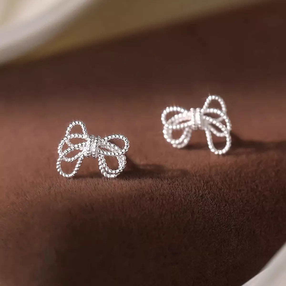 Sterling silver bow knot stud earrings by Plush Fashion Hub, featuring a polished, elegant design for everyday wear.