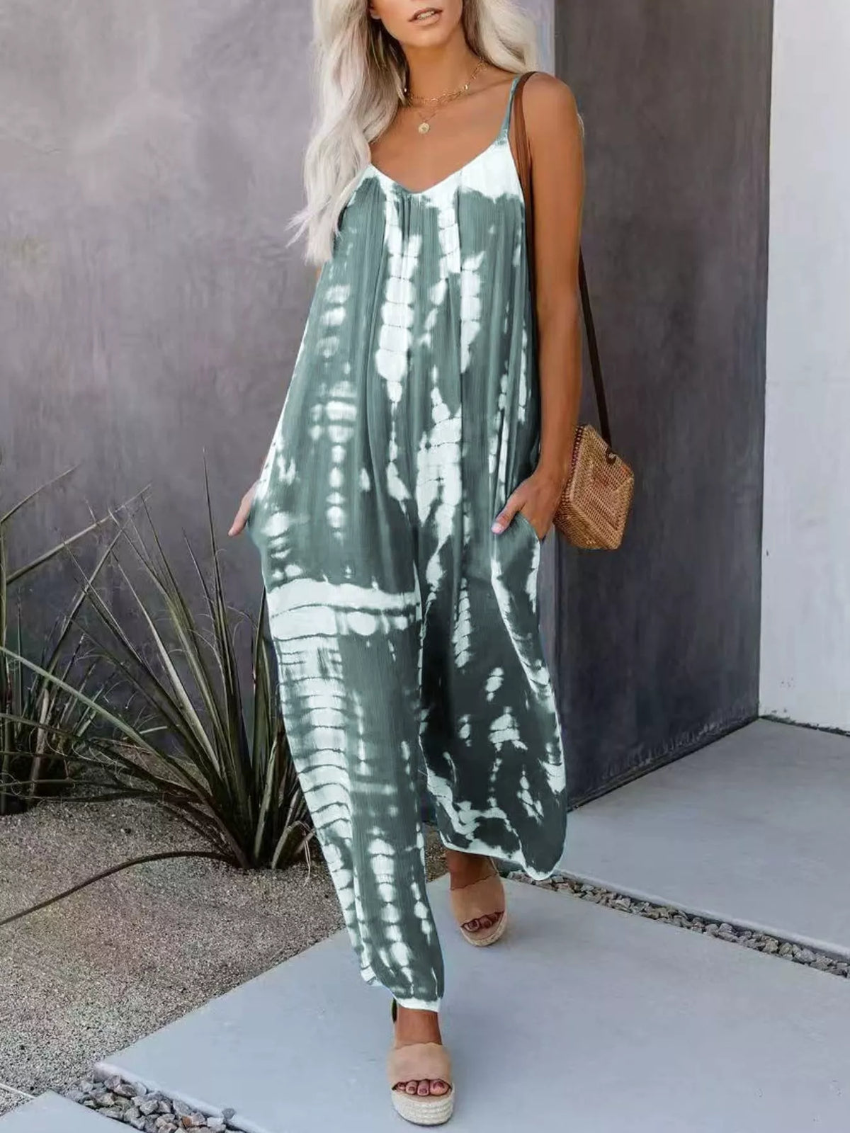 Plus size tie-dye wide leg jumpsuit by Plush Fashion Hub, full-length with flowing fabric and vibrant pattern.