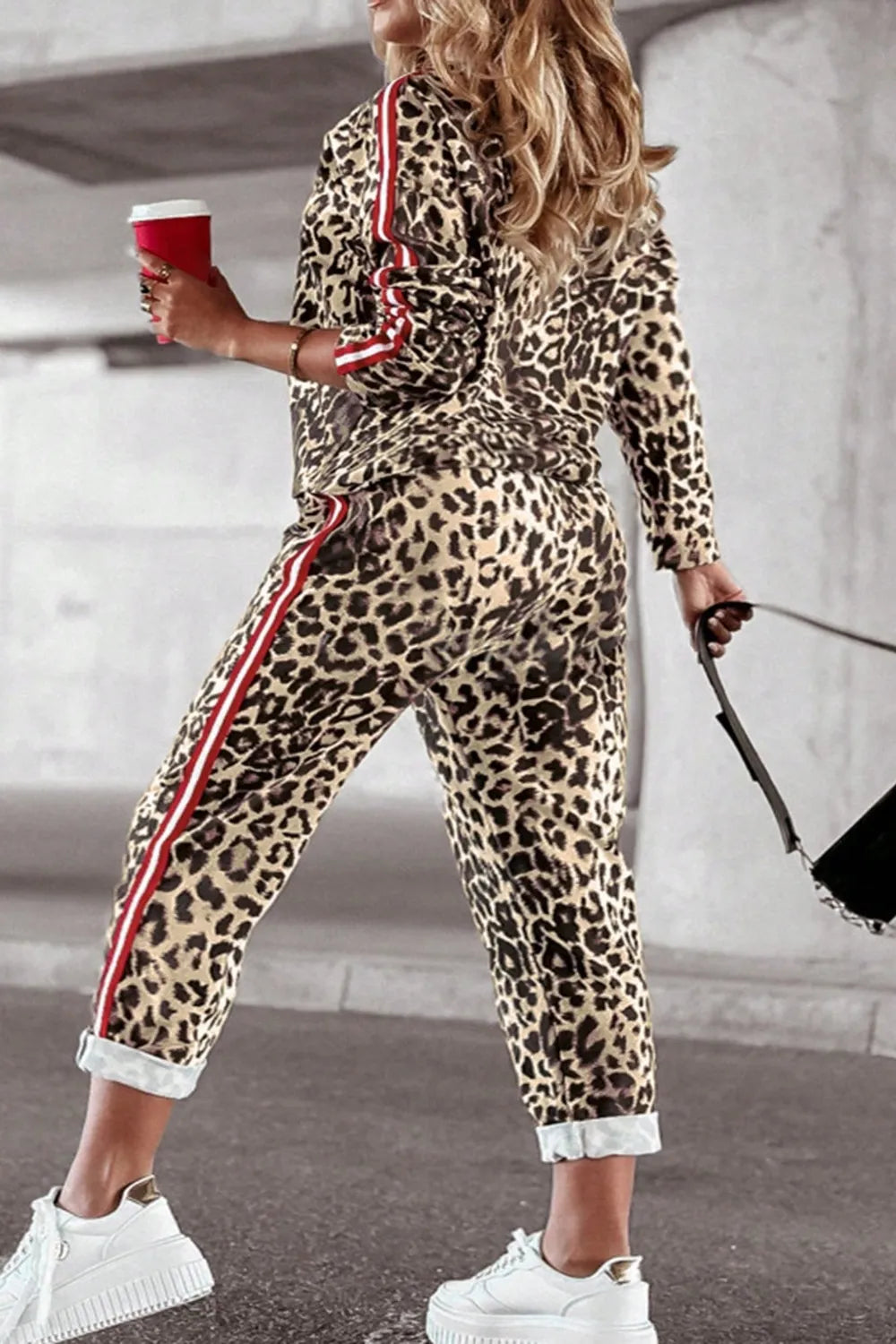 Plus size leopard print round neck top and pants set by Trendsi, showcasing a stylish, coordinated outfit with bold animal print.