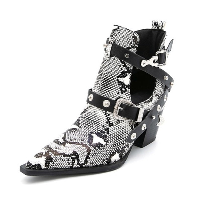 Black and white snakeskin ankle boot with pointed toe, cutout sides, black straps, silver buckles, and studs.